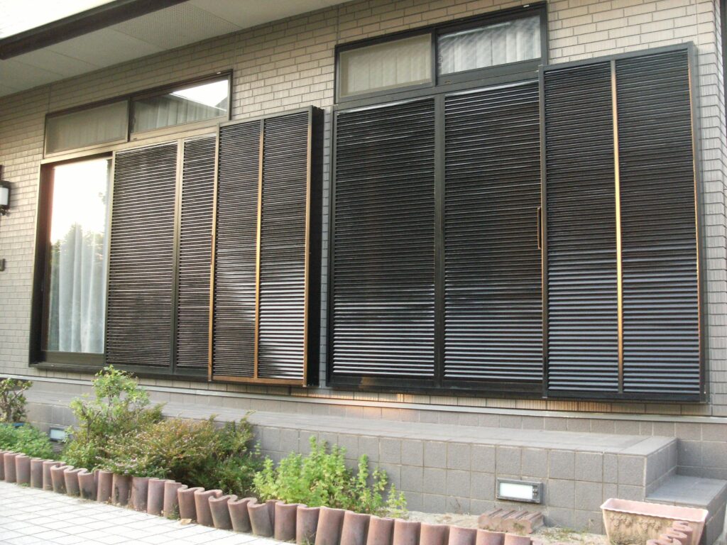 Inspecting the roof and cleaning gutters on a traditional Japanese house before typhoon season.